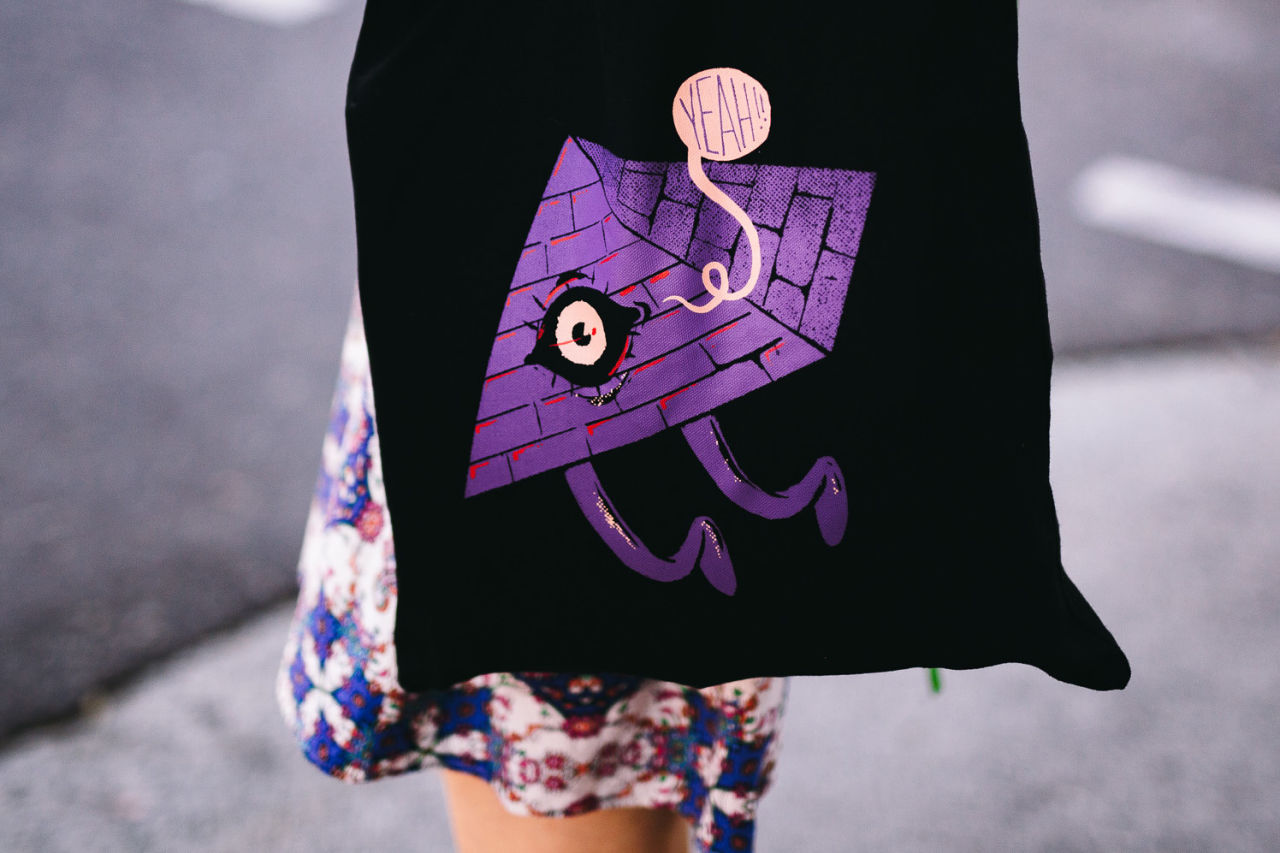 A photograph of a woman wearing a Bigsound branded tote bag.